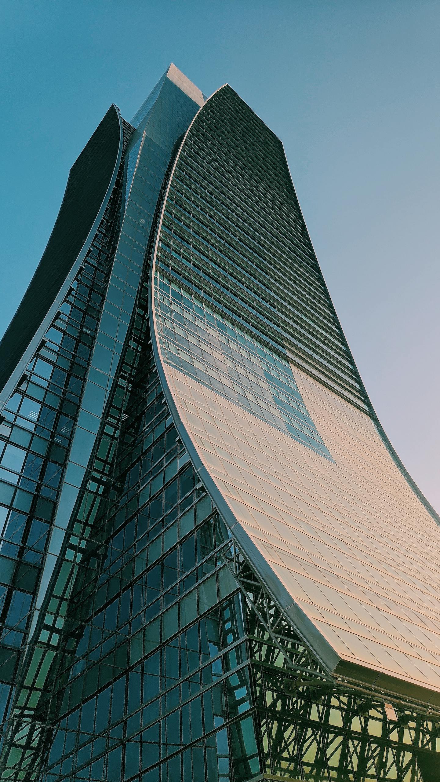 A contemporary curved skyscraper reaching towards the sky, showcasing modern architectural design.